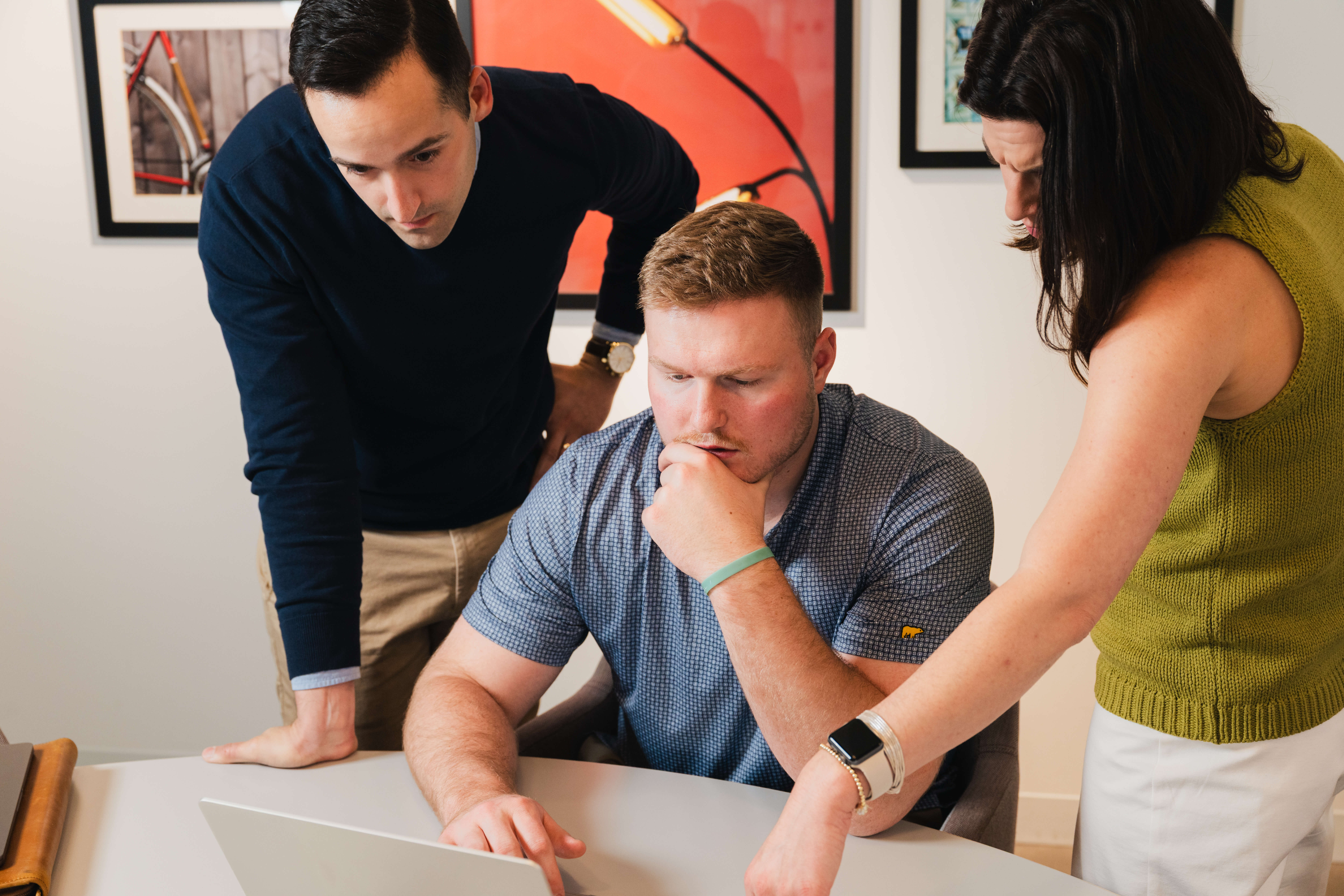 Three members of the Refresh team reviewing a website together on a laptop